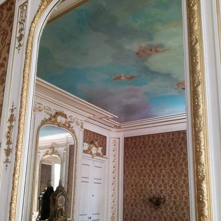 Miroir doré ancien reflétant le faux ciel peint au plafond