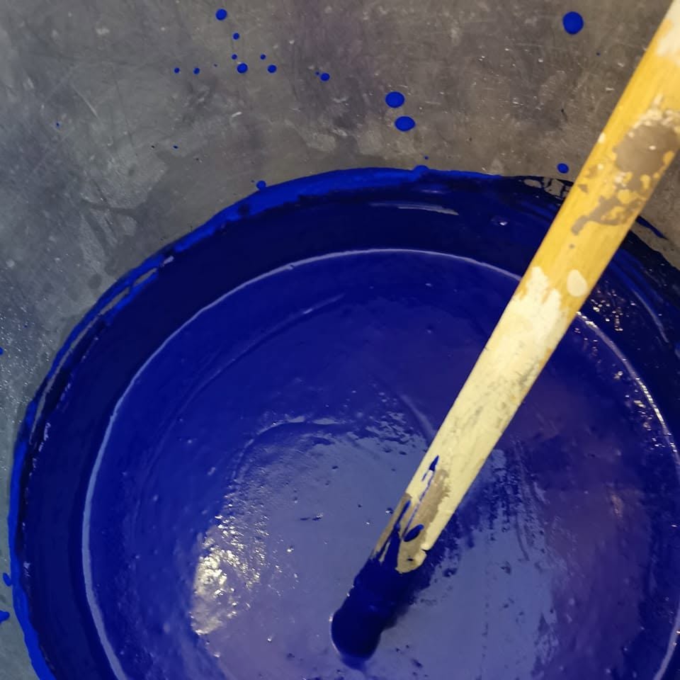 Pot de peinture bleu outremer et pinceau préparés à l'atelier