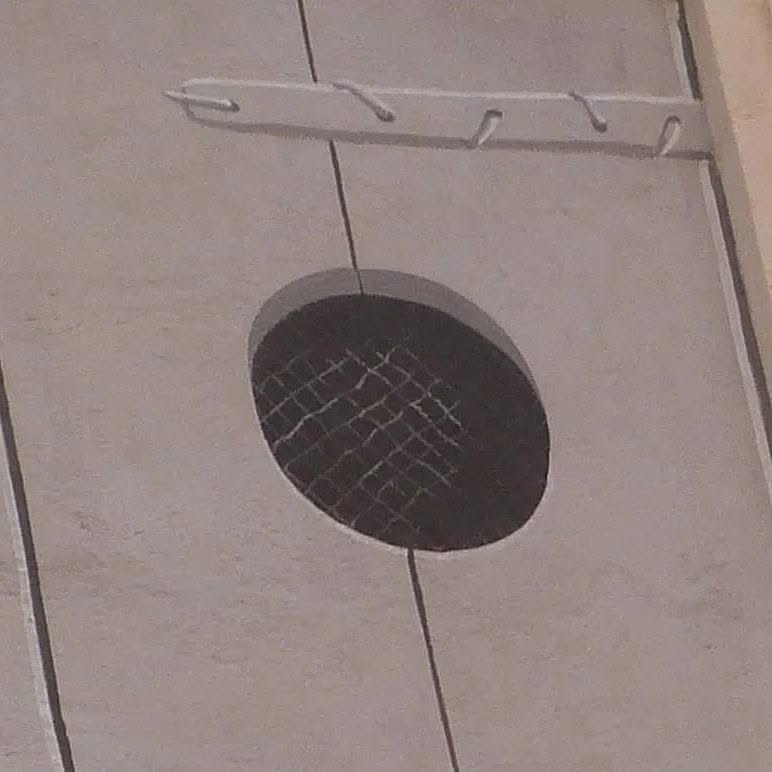 Grille ronde peinte en trompe-l'œil sur un plafond clair